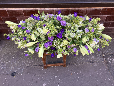 Violet Meadow Casket Spray - A graceful casket spray featuring shades of lavender, violet and white, arranged with seasonal flowers and foliage.