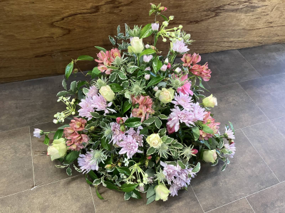 Blush Front-Facing Arrangement - A beautifully handcrafted front-facing arrangement in soft pink, blush and fresh green tones, created with seasonal flowers to offer a graceful and elegant tribute.