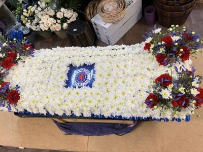 Personalised Coffin Tribute - A handcrafted coffin tribute with a white floral base and personalised focal design, created with seasonal flowers to honour a loved one's life, passions or cherished memories.